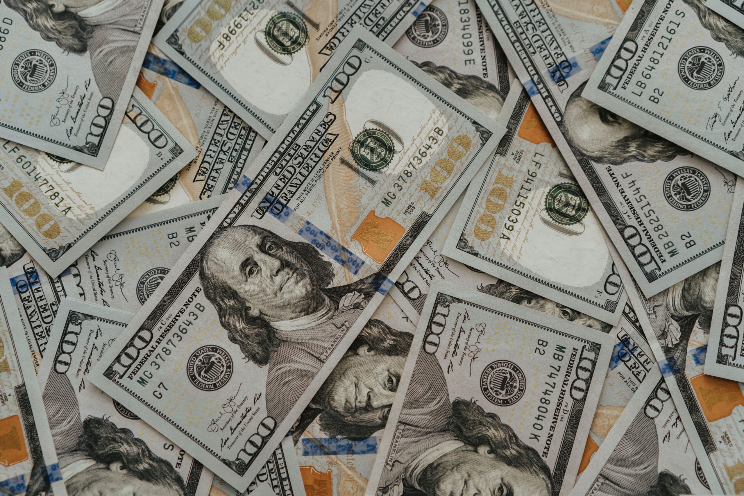 Home Close-up of American 100 dollar bills scattered, highlighting wealth and currency concepts.